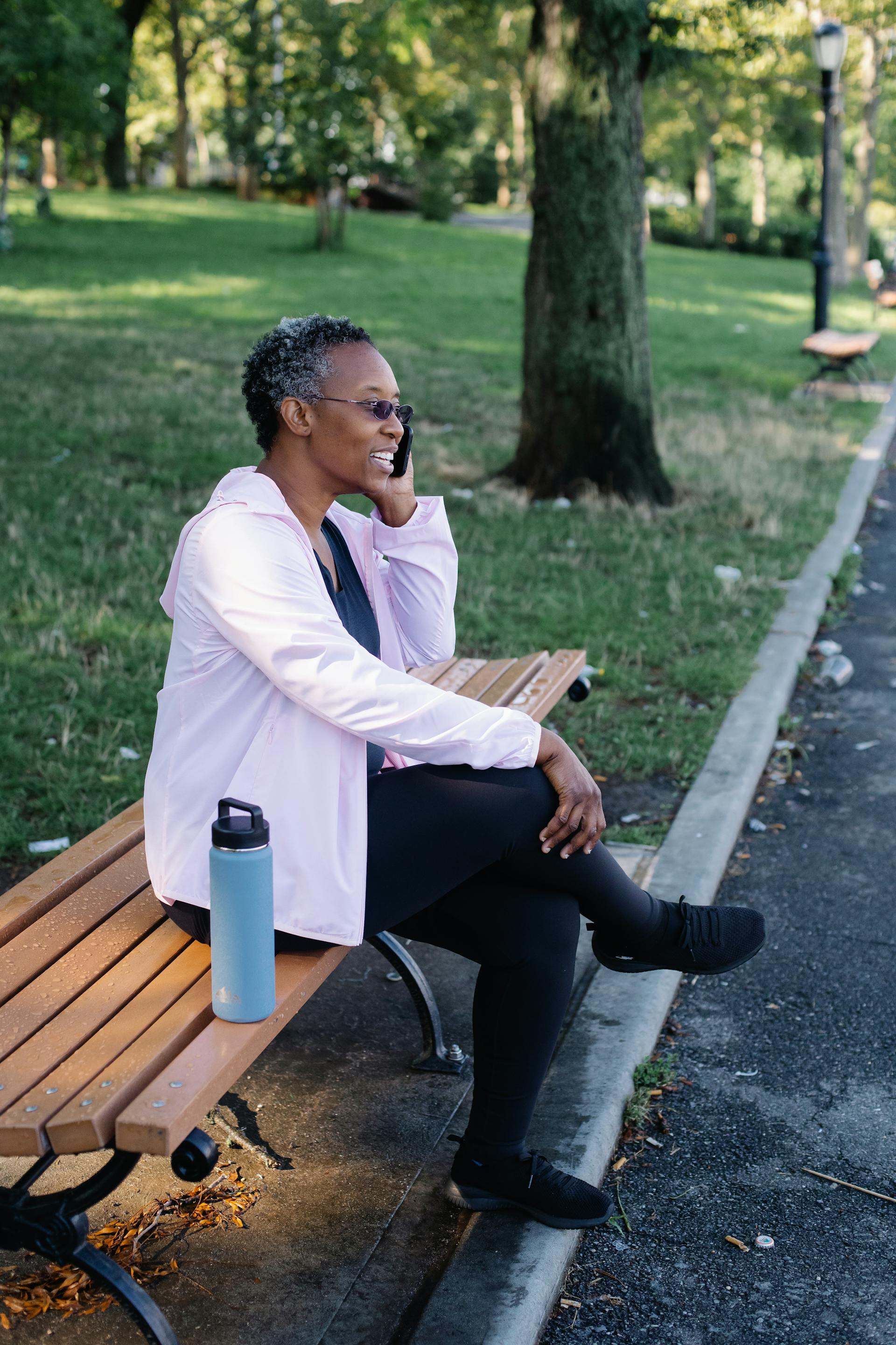 Senior woman with silver hair waving and smiling warmly during a Social Circle video call session